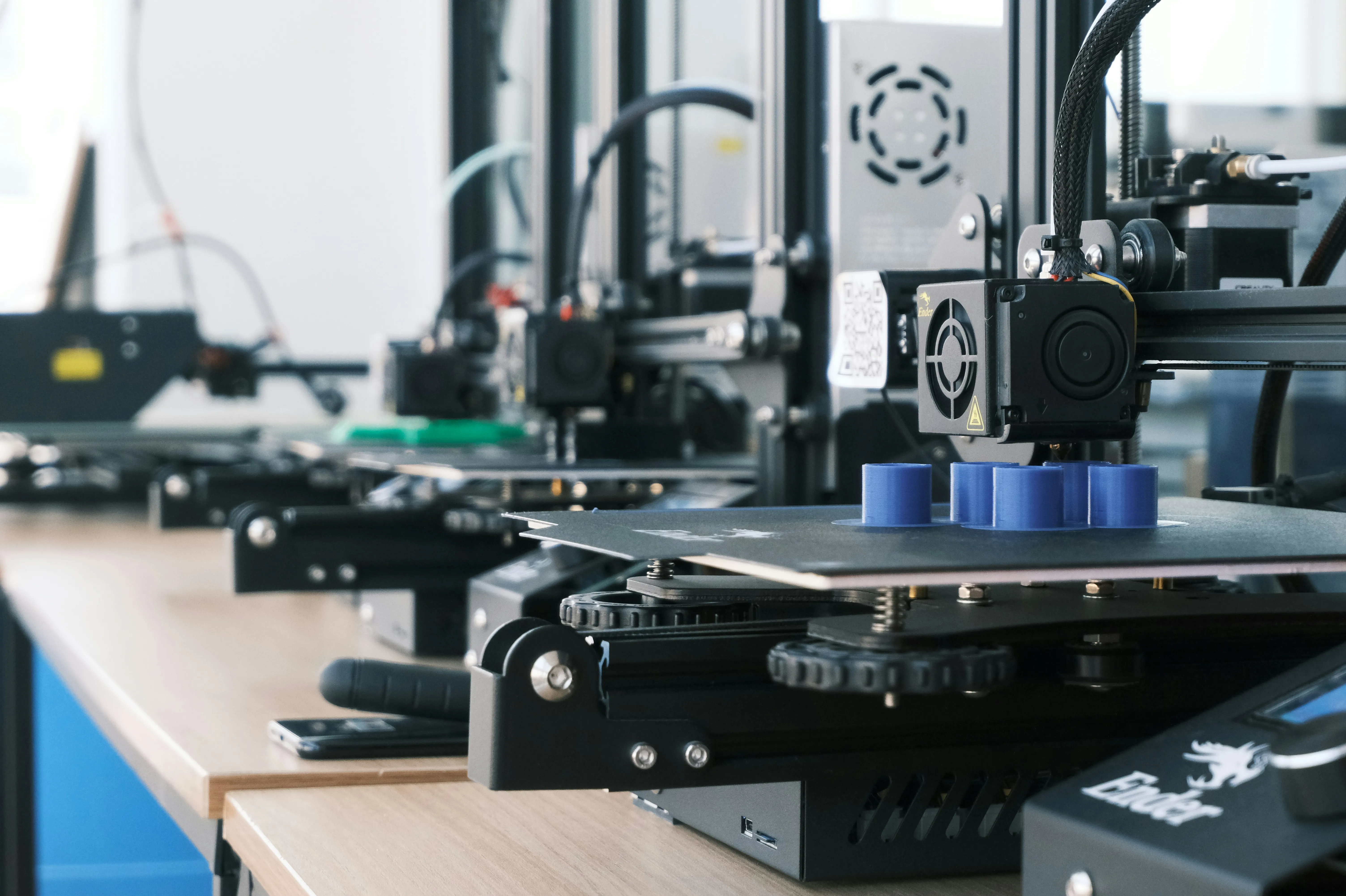 Niz 3D pisača tijekom izrade plavih plastičnih dijelova
